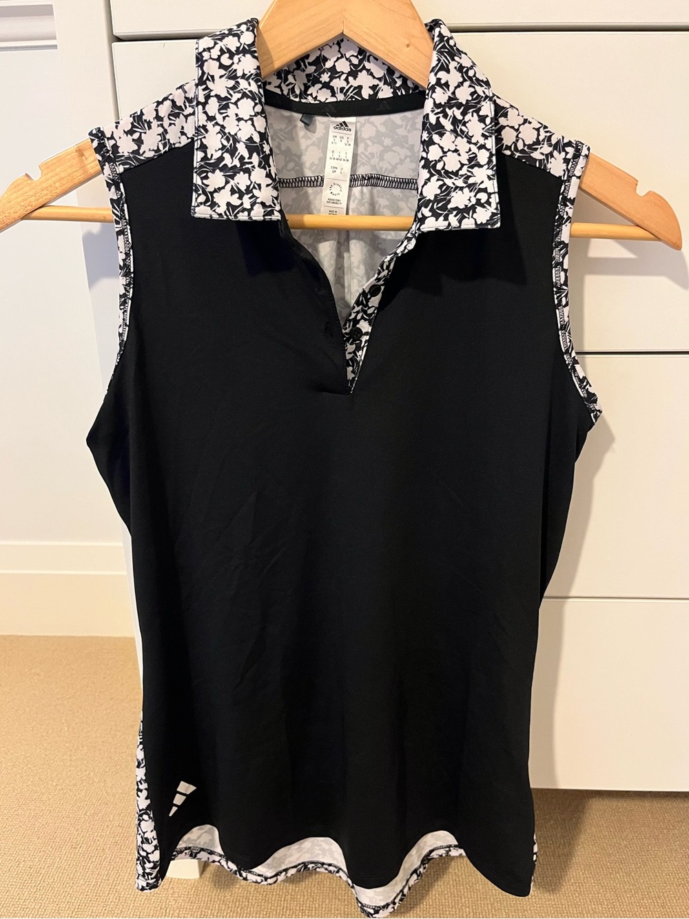 Sleeveless golf shirt with black and white floral design